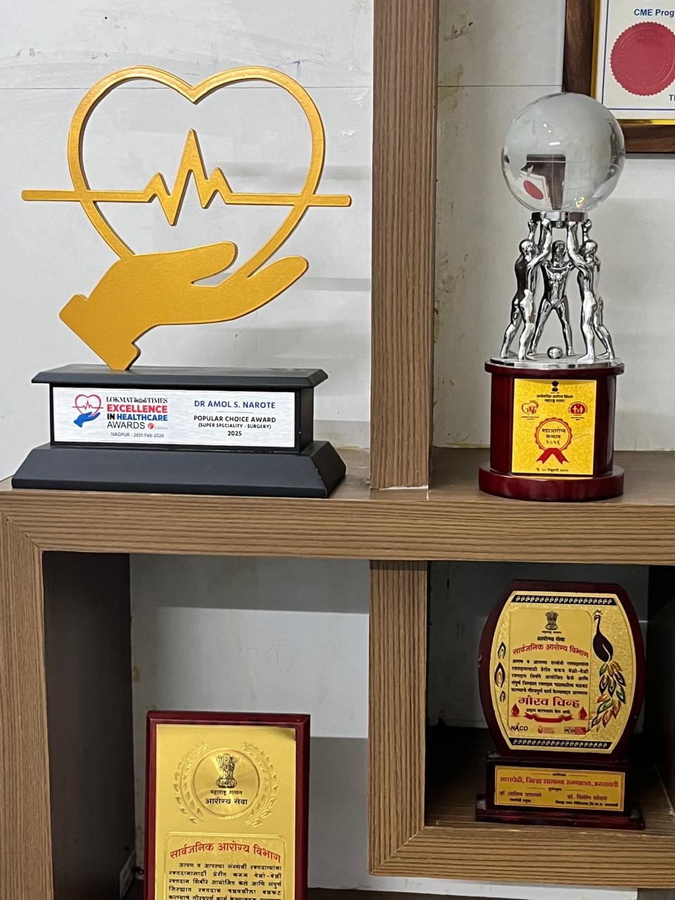 Display shelf of trophies and awards at RRSH Amravati including Lokmat Excellence in Healthcare and Maharashtra Gaurav Chinh