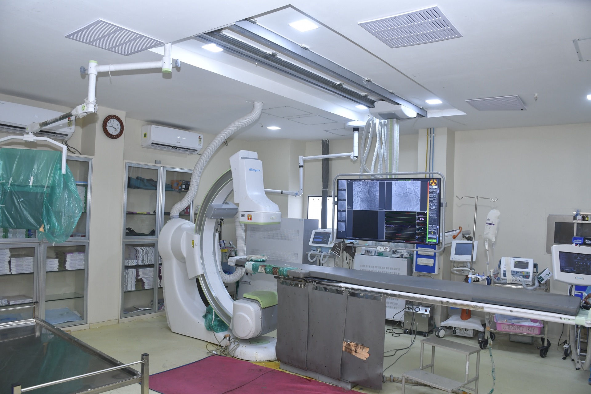 Cardiac catheterisation laboratory with C-arm angiography system and patient table