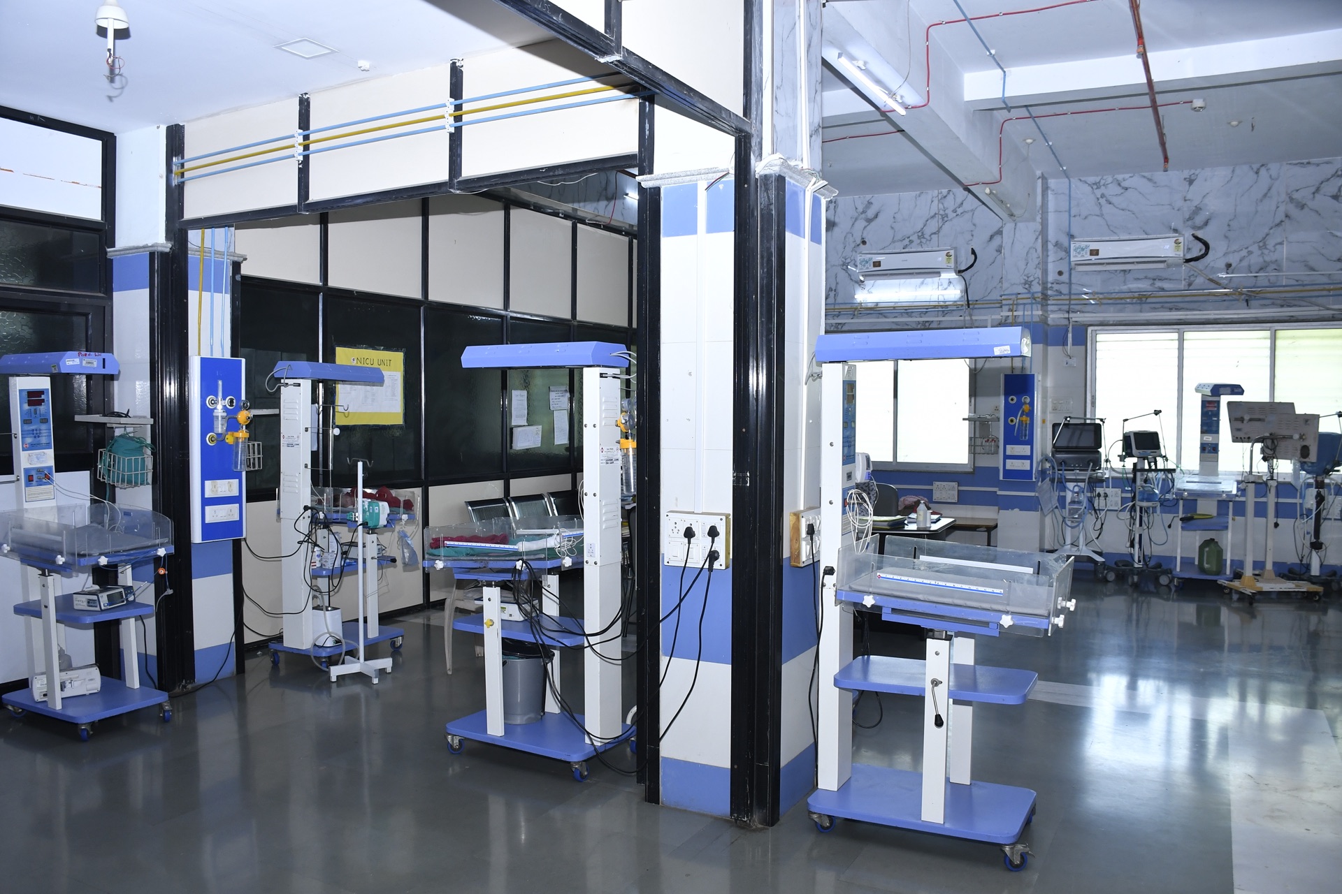 Row of neonatal infant warmers and incubators in the NICU at RRSH Amravati