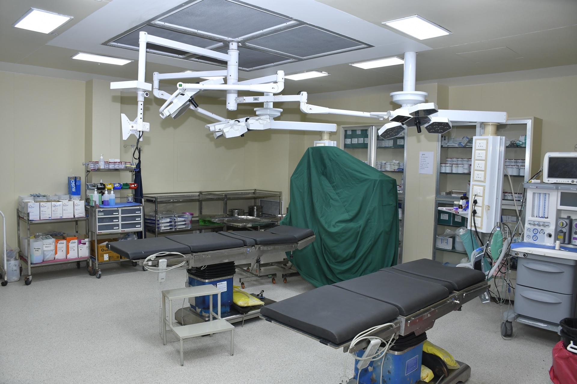 Operating theatre with dual overhead surgical lights and equipped table at RRSH Amravati